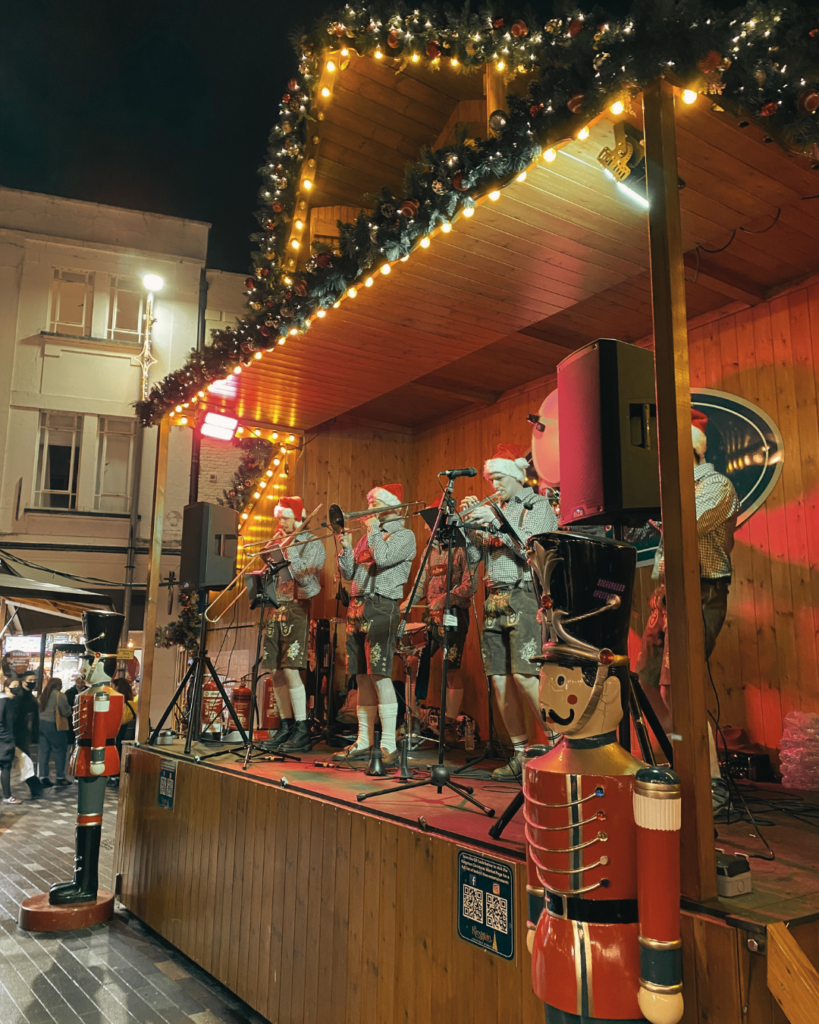 A traditional bavarian oomparty band playing on stage at Kingston Christmas Market at nighttime